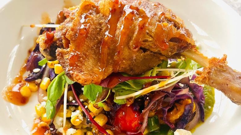 Crispy duck leg on bed of fresh vegetables