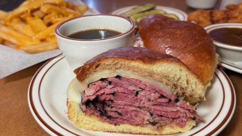 Pastrami sandwich on table with fries in background