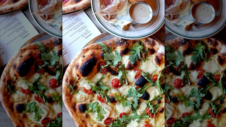 Wood-fired pizza with arugula and tomatoes