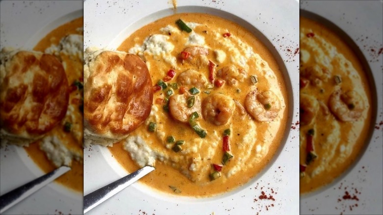 Bowl of shrimp and grits with biscuit on the side