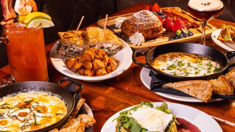 Assortment of sandwiches, desserts, and cocktails on table