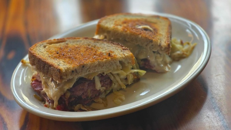 Reuben sandwich cut in half on plate