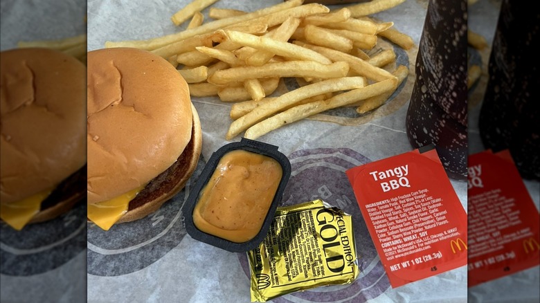 McDonald's fries and cheeseburger with special edition gold sauce, tangy BBQ sauce, and a soda