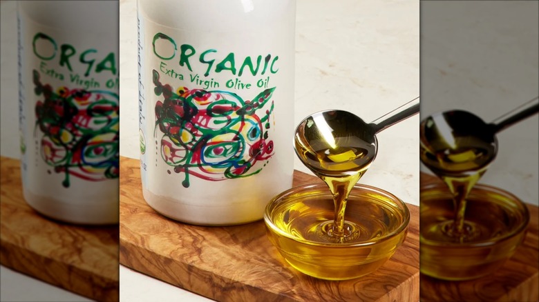 Bottle of Arte organic extra virgin olive oil being spooned into small dish.