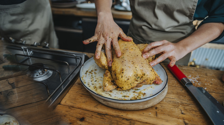 Person preparing chicken for roasting