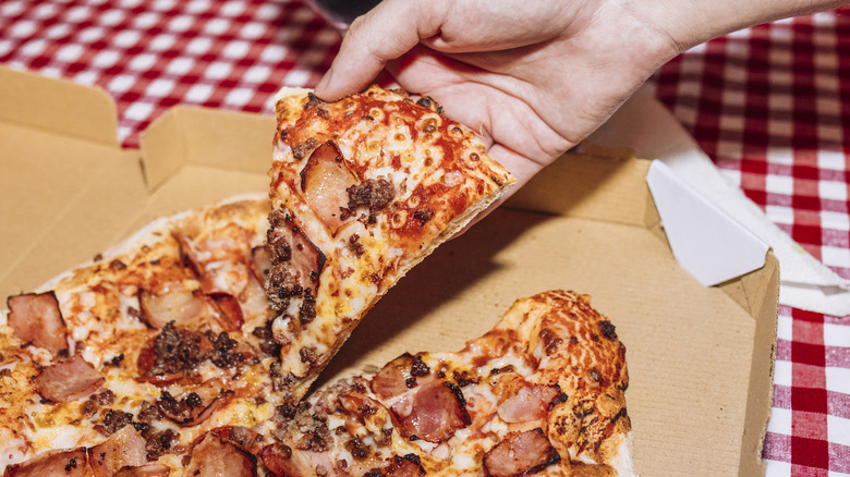 Hand grabbing pizza