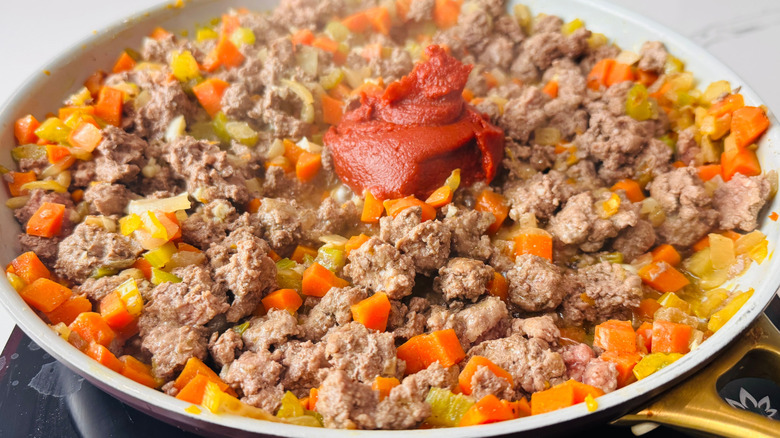 Meat and veggie mixture with dollop of tomato paste in the middle
