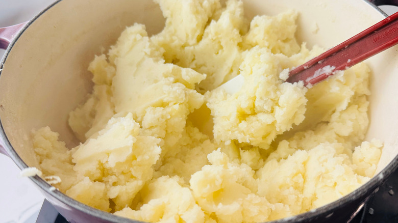 Mashed potatoes and rubber spatula in large pot