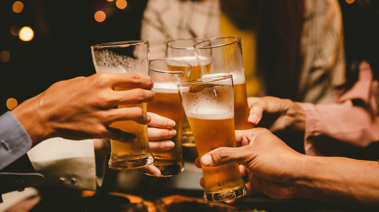 Friends clinking together glasses of beer
