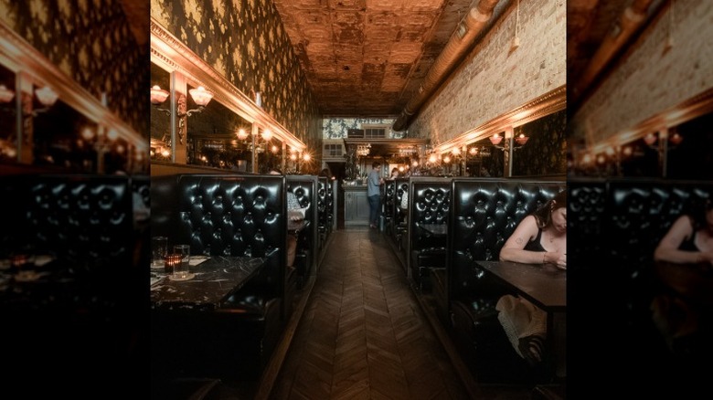 The inside of a bar, with black vinyl booths