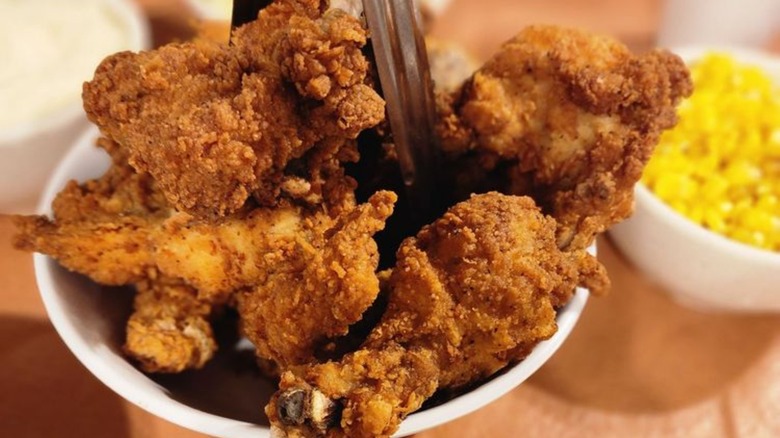 Bowl of fried chicken with side of corn.