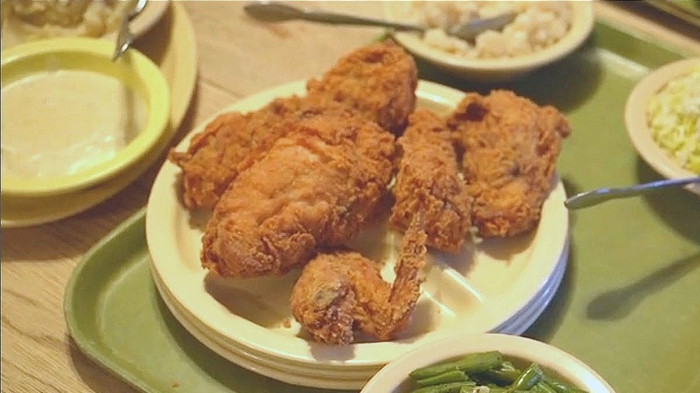 Fried chicken on tray with slaw and green bean sides..