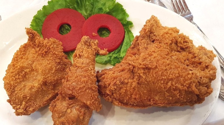 Three pieces of fried chicken on plate with garnish.