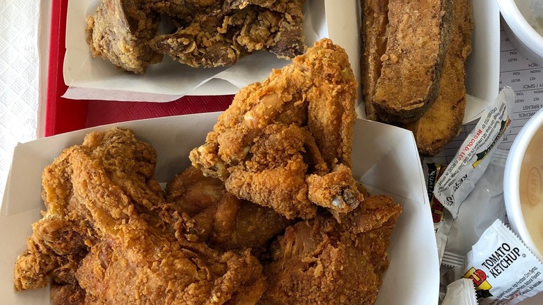 Fried chicken and sides in paper trays.