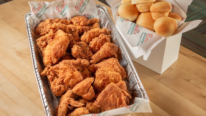 Tray of fried chicken with box of rolls.