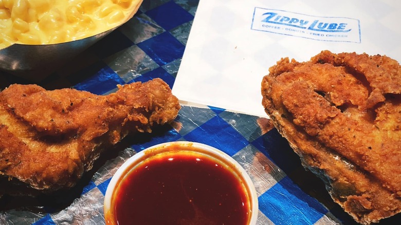 Pieces of fried chicken with sauce and logo napkin.