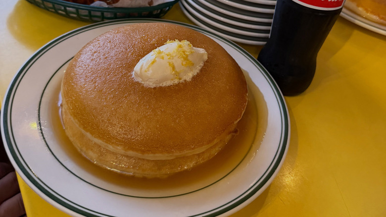 A plate of pancakes with butter and syrup at Golden Diner