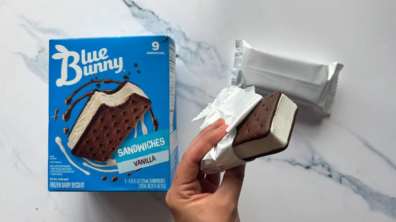 Blue Bunny ice cream sandwich box and a hand holding one unwrapped treat