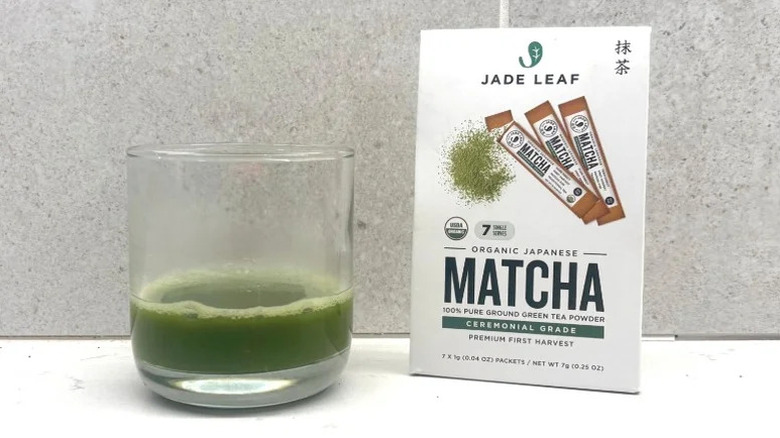 Jade Leaf Matcha package next to short glass of matcha mixed with water