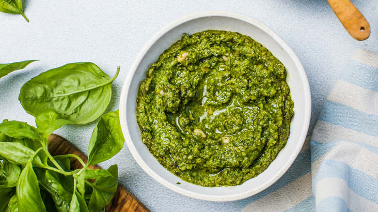 pesto in bowl with basil leaves