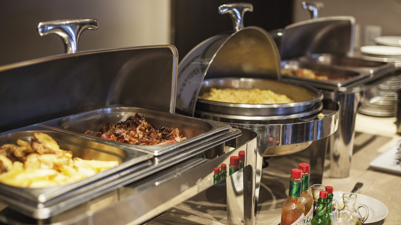 A breakfast buffet in silver metal serving dishes.
