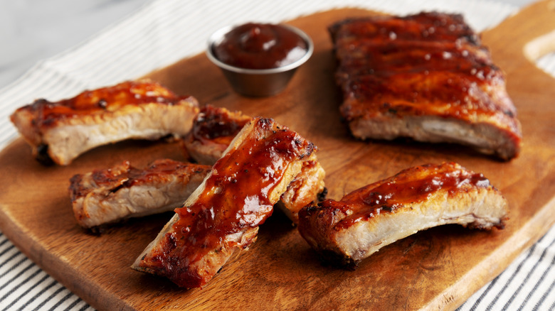 Oven-baked baby back ribs cut from the full rack with barbecue sauce
