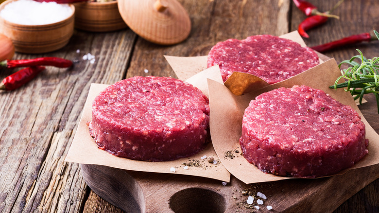 Three raw ground beef patties.