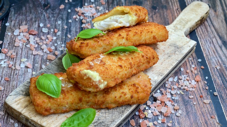 Crispy fried fish sticks on a cutting board