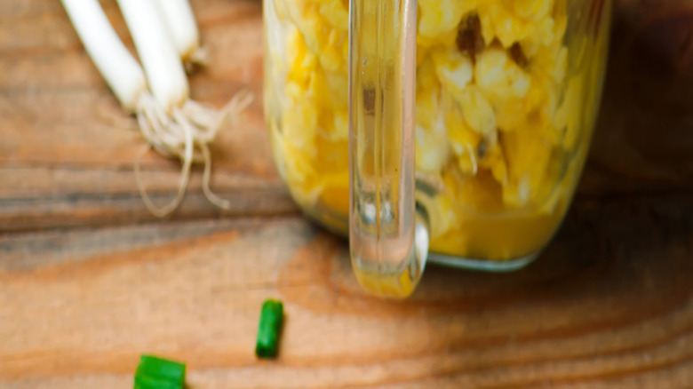Eggs and scallions and bacon in a mason jar with fork