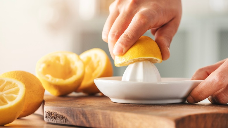 Person squeezing lemons with a juicer