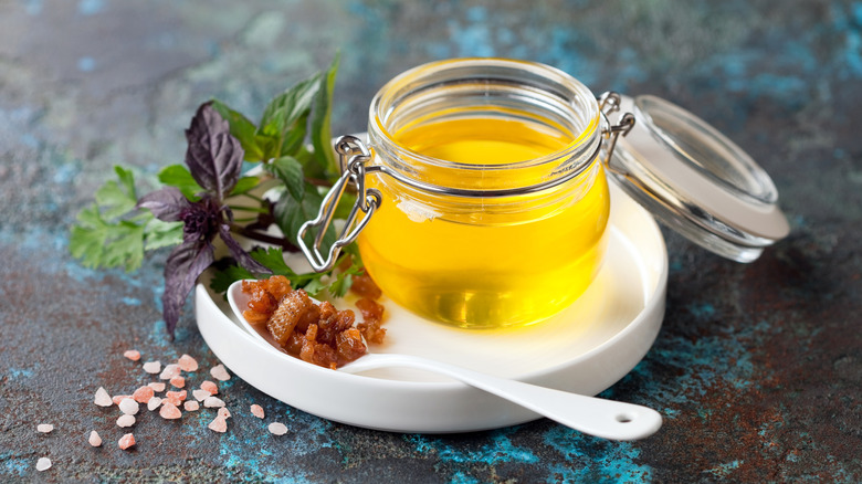 Open jar of rendered duck fat on a white plate