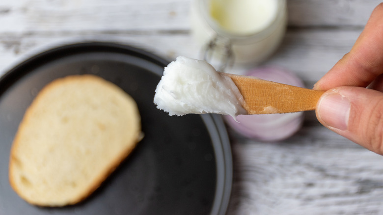 Person holding scoop of lard