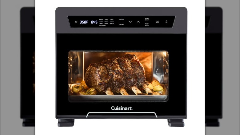 The Cuisinart Extra-Large 26L 10-in-1 Digital Air Fryer Oven in a black finish, with meat roasting inside