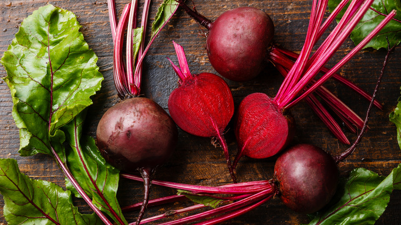 Fresh beets in center of wood table.