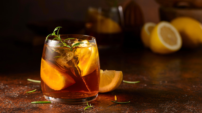 a cup of rosemary tea with a sprig of rosemary and a slice of lemon