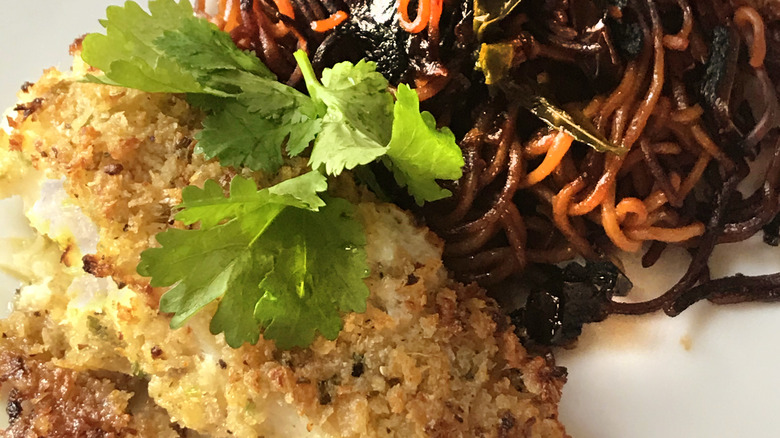 breaded baked fish with side of noodles