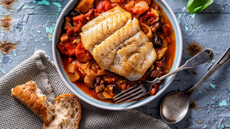 pan seared fish on a bed of tomato sauce and veggies