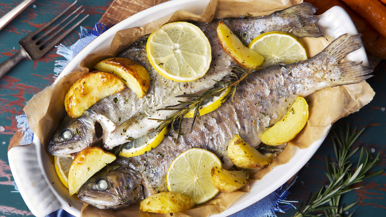 oven roasted trout in casserole dish with lemons
