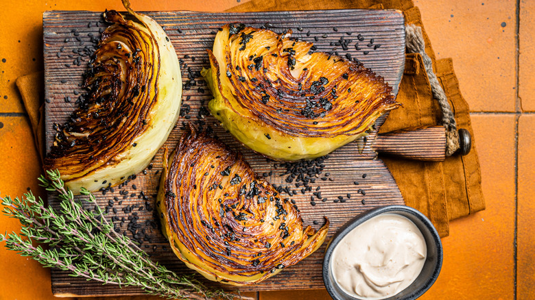 roasted cabbage wedges sliced and sitting on a wooden board