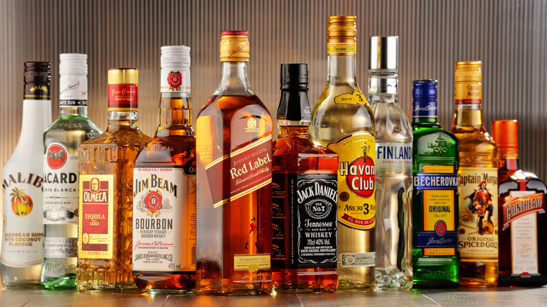 A row of various spirits sits on a tile counter