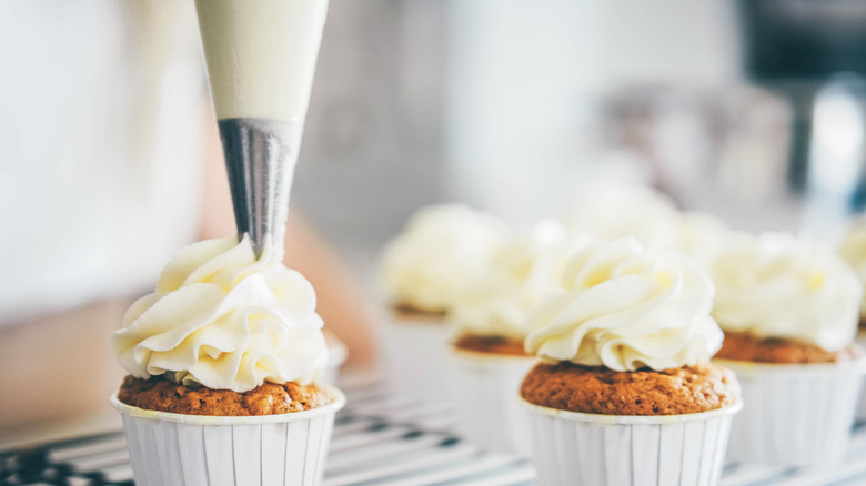 piping tip over muffins with buttercream frosting
