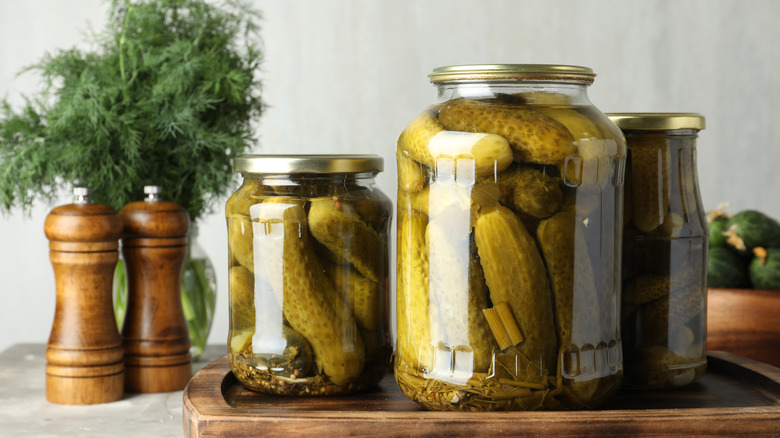 Jars of pickles on a wooden cutting board