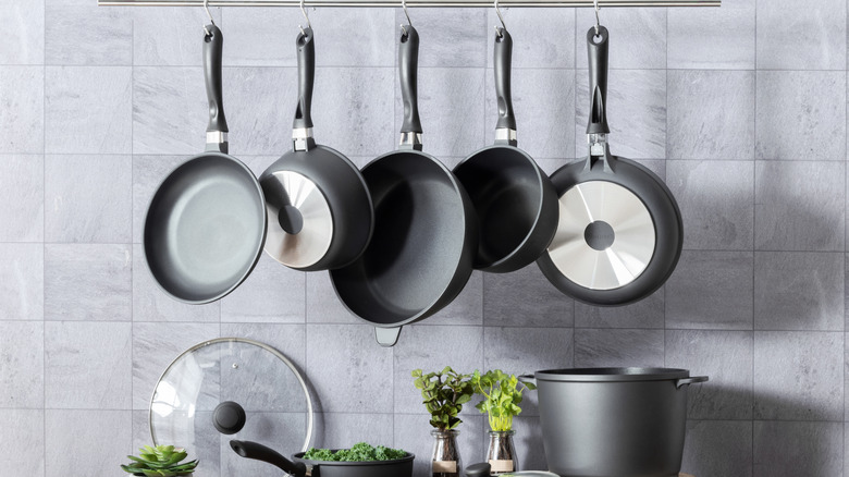 pots and pans hanging from a pot hanger in a modern kitchen