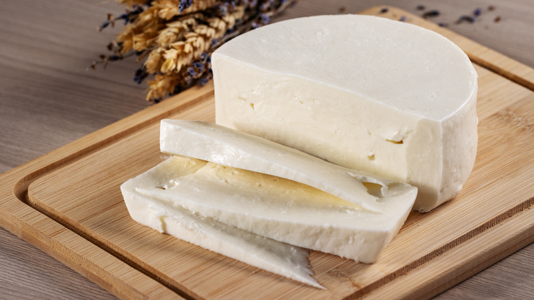 White round cheese on a cutting board