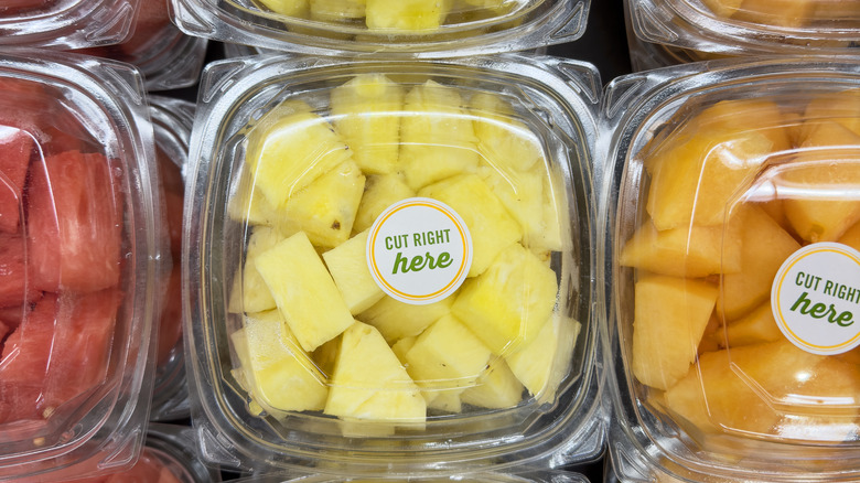 Overhead view of pre-cut pineapple and melons packaged in a grocery store