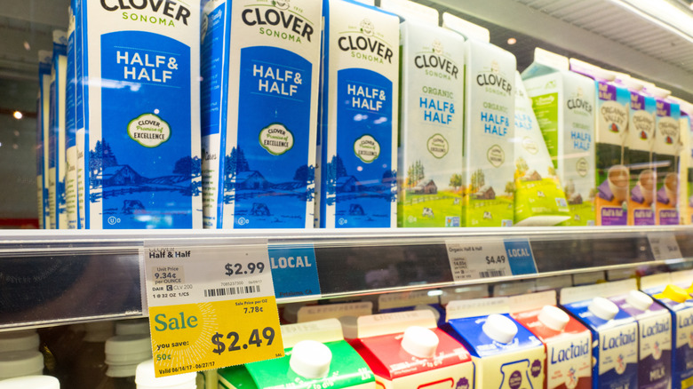 Half and half on a shelf in the grocery store with a sale sign next to it