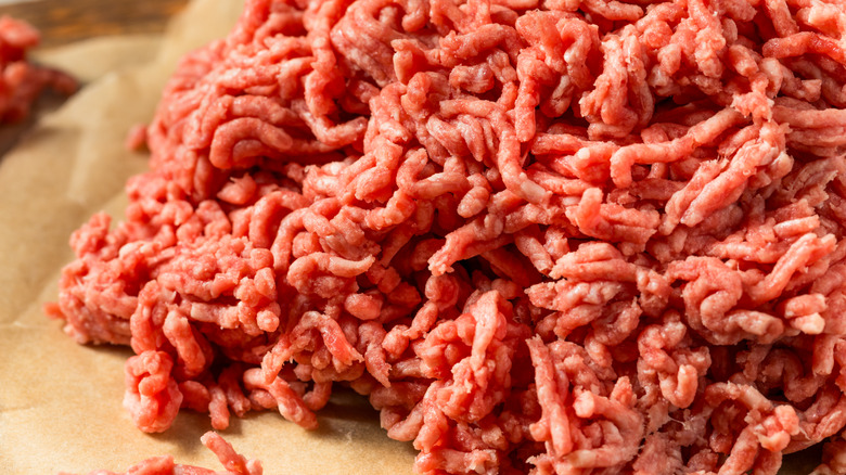 A pile of ground beef on brown paper.