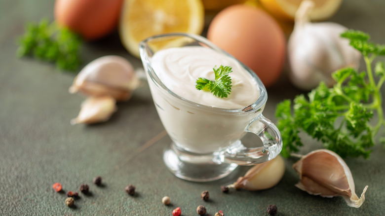 A serving of garlic aioli, with fresh produce behind it