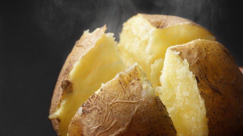 Steaming baked potatoes cut into four squares, revealing its core