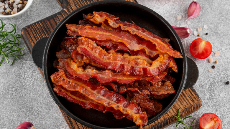 Cooked bacon in pan over a wooden board